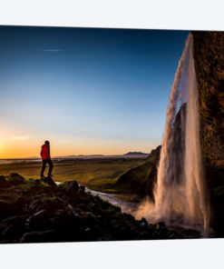 A Lone Figure In Front Of Seljalandfoss, Sudurland, Iceland, At Midnight